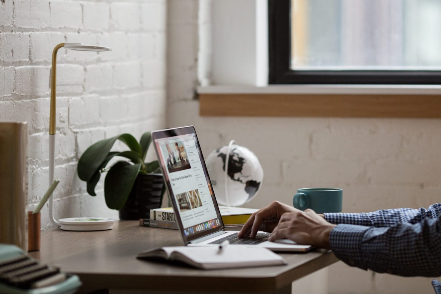 A man diligently working on a laptop at a desk, focusing on the MOST IMPORTANT things to review on your website.