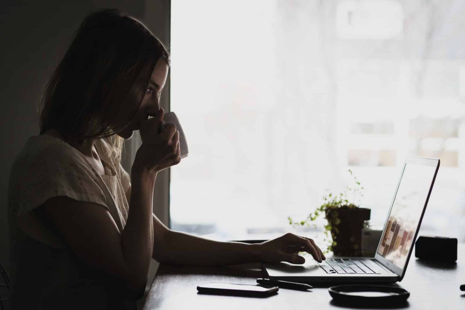 An 18-year-old woman working from home on her laptop.